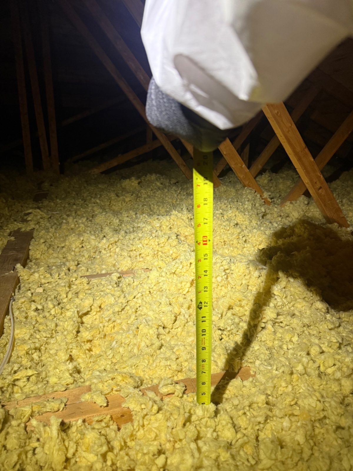 The tape shows 4&ndash;5&Prime; of old insulation &mdash; barely a quarter of today&rsquo;s standard.
