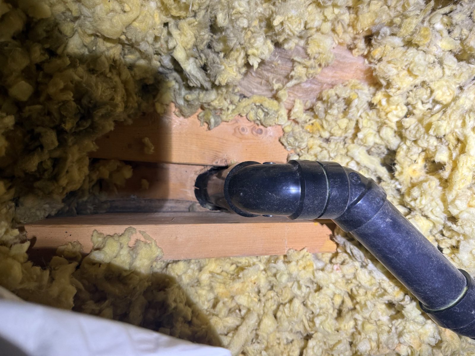 An open, unsealed gap around the plumbing stack &mdash; a permanent air leak into the attic.