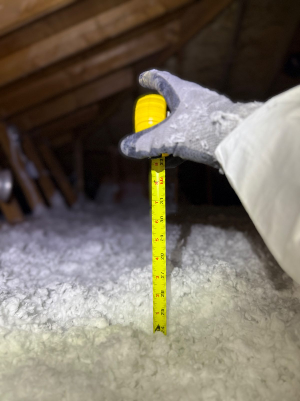 The depth check: a full R-60 reading in fresh insulation.