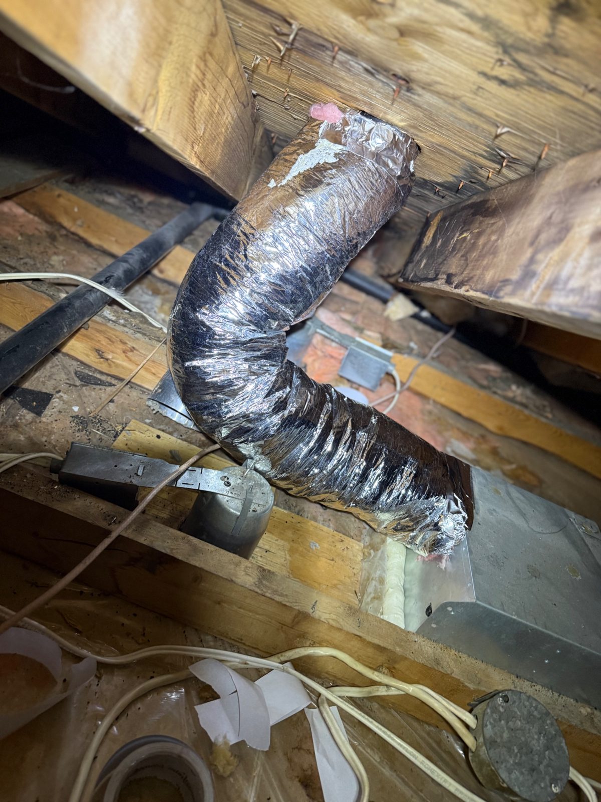 The new insulated bathroom exhaust duct — steam now travels through the roof, not onto it.