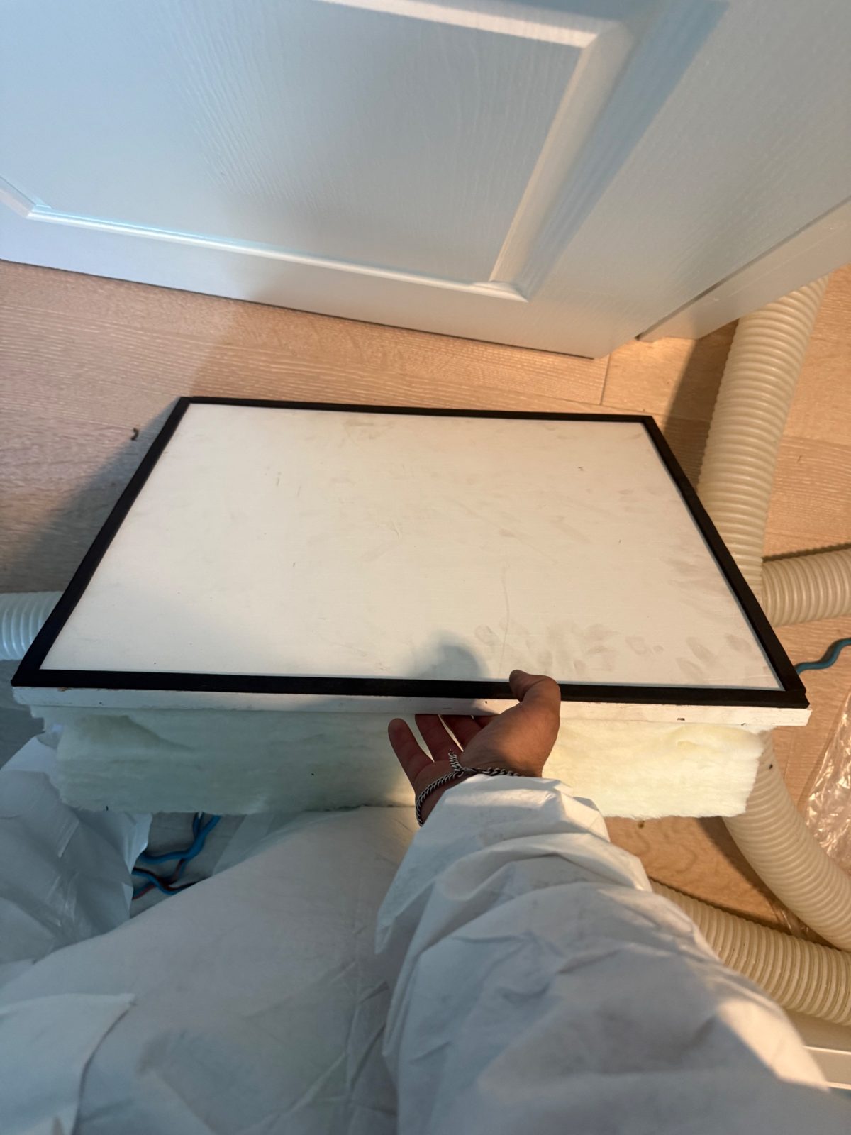 The new insulated, weatherstripped attic hatch — the last air leak, closed.