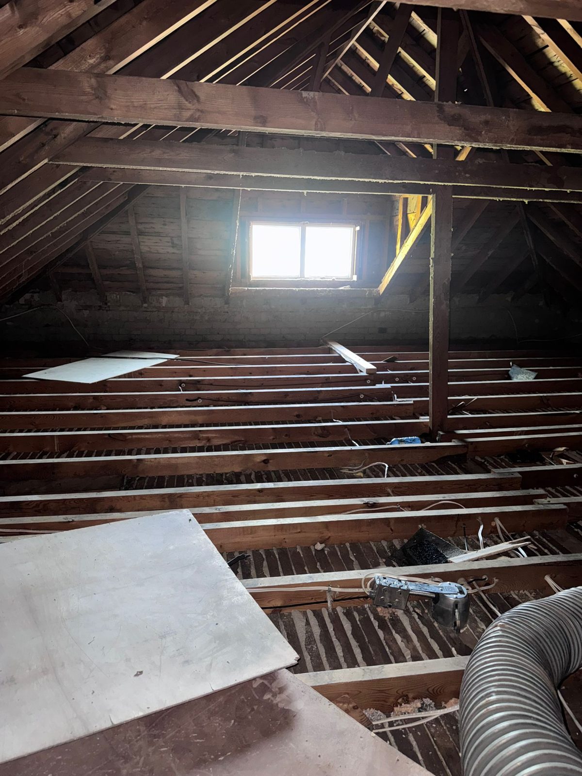 Step 1 — stripped to bare joists: all 1,000 sq ft of contaminated insulation removed and disposed of.